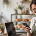 Café owner checking her phone while reading what AI search says about her business
